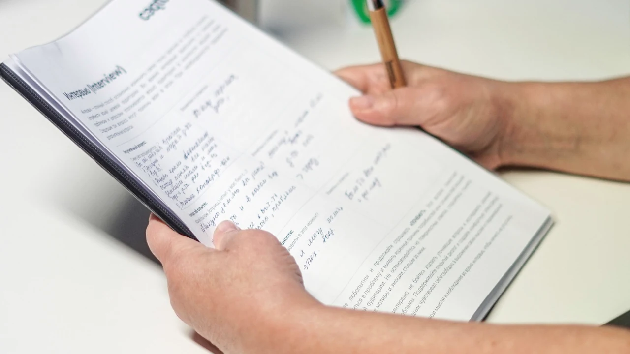 書き込みのある学修資料を読み返す手元