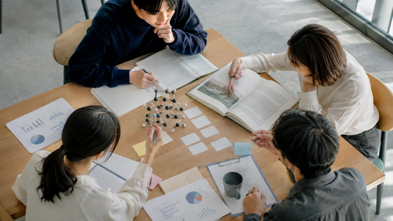 異なる分野の資料を囲み、専門同士のつながりを考える学生のイメージ